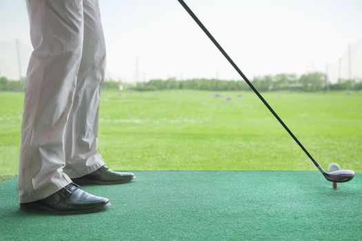 Low angle view of man getting ready to hit a golf ball