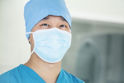 Portrait of young surgeon wearing surgical mask in the operating room, close- up