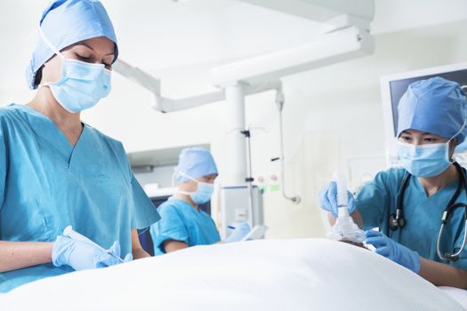 Team of surgeons working with a patient lying on the operating table