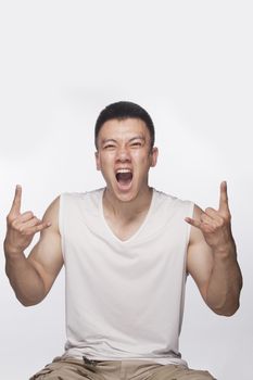 Excited man making hand sign with mouth open, studio shot