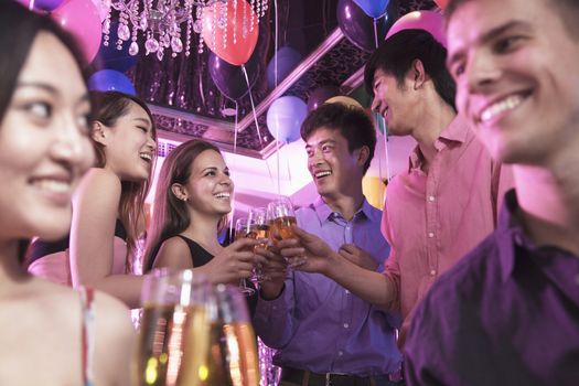 Group of friends celebrating, toasting with champagne, nightclub in Beijing