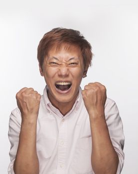 Excited man with fists raised and mouth open, studio shot