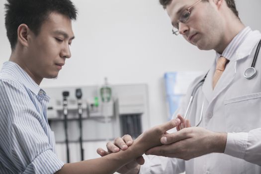 Doctor checking patients pulse on the wrist