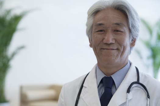 Portrait of mature doctor looking at camera and smiling
