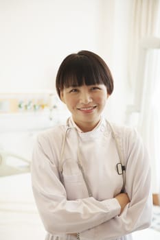 Portrait of smiling young female doctor with arms crossed in a hospital 