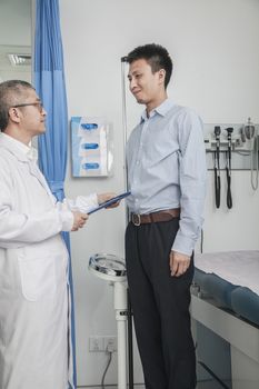 Doctor standing and facing a patient in the doctors office