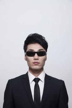 Cool businessman with sunglasses, studio shot