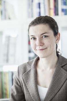 Portrait of smiling young businesswoman looking at the camera, head and shoulders