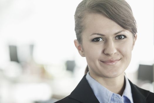 Portrait of smiling young businesswoman with bangs looking at the camera, head and shoulders