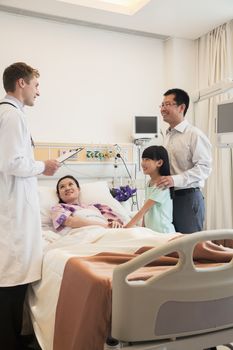 Family visiting the mother in the hospital, discussing with the doctor