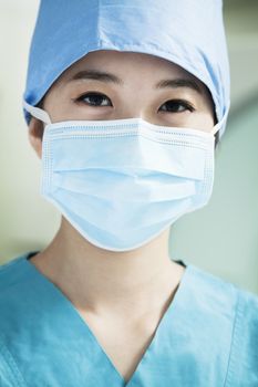 Portrait of young female surgeon wearing surgical mask in the operating room, close- up