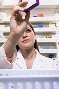 Pharmacist taking down and examining prescription medication in a pharmacy