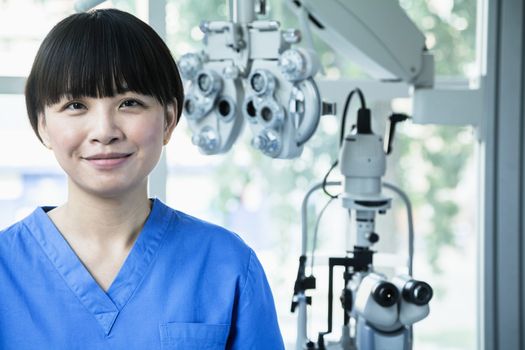 Portrait of smiling female optometrist with eye test equipment