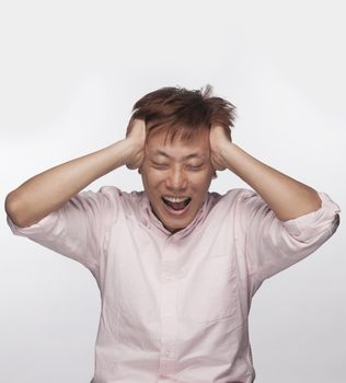 Frustrated man with hands on head and mouth open, studio shot