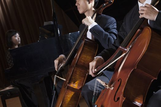 Two cellists playing the cello during a performance