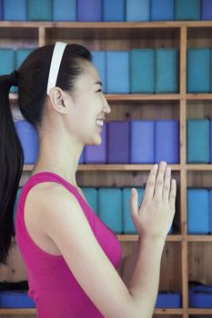 Portrait of young women doing yoga with hands clasped together, side view