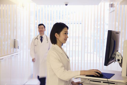 Young female doctor using the computer in the hospital, Beijing, China