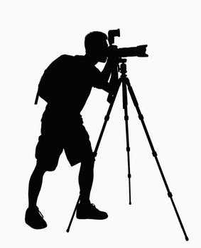 Silhouette of man taking pictures with camera on tripod.