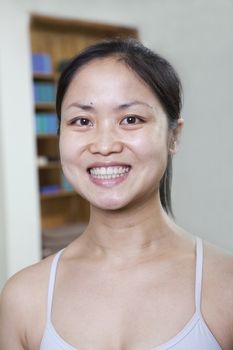 Portrait of smiling woman in a yoga studio, head and shoulders