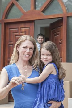 Mother and daughter smiling and holding the keys to their new house