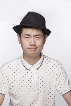 Portrait of serious young man wearing a hat, studio shot