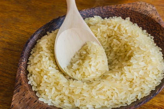 Rice on the plate with a wooden spoon