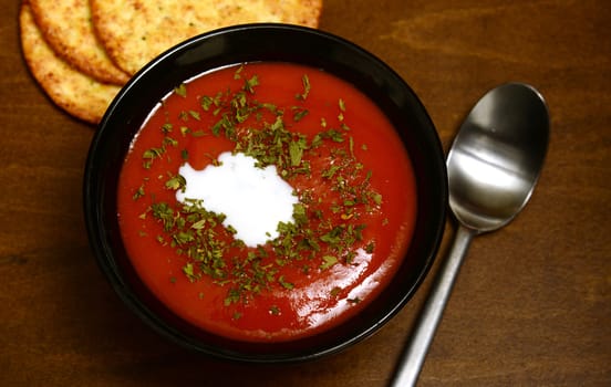 tomato soup and crackers on a rustic wooden background