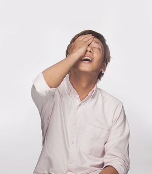 Anxious man with hand over face, studio shot