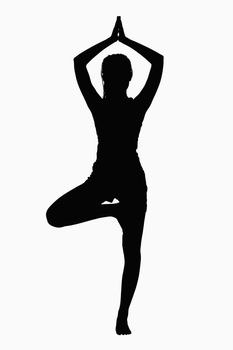 Silhouette of woman doing yoga pose.