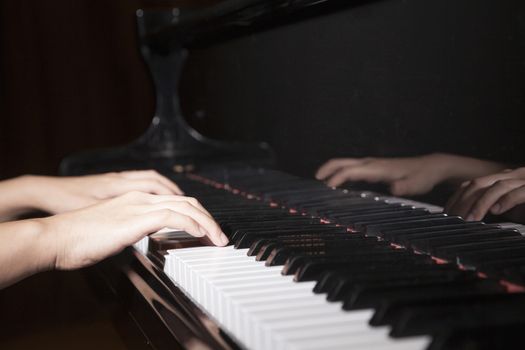 Close-up of hands playing the piano
