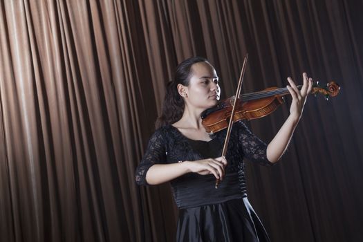 Violinist standing and playing the violin at a performance