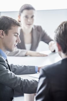 Three business people sitting at a table and having a business meeting in the office