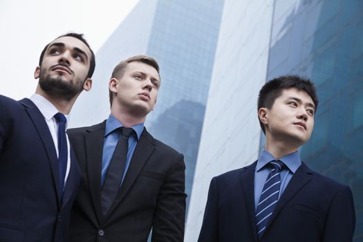 Portrait of three serious businessmen, outdoors, business district 