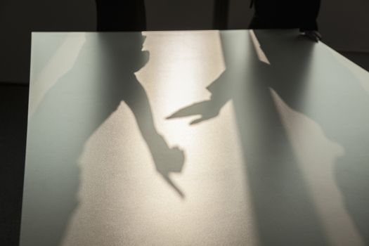Shadow of two business people arguing and gesturing on the floor of the office