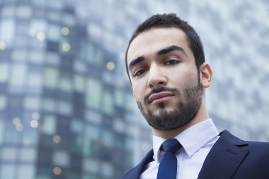 Portrait of serious young businessman, outdoors, business district