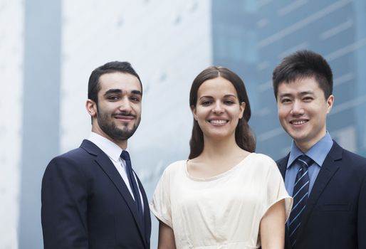 Portrait of three smiling business people, outdoors, business district 