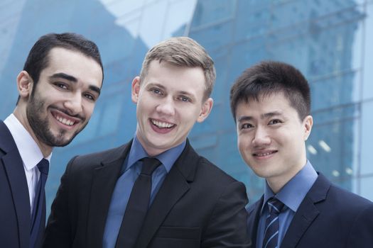 Portrait of three smiling businessmen, outdoors, business district 