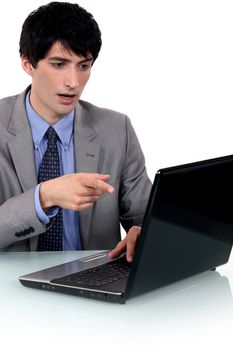 Surprised businessman pointing at his laptop