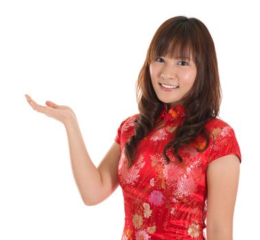 Pretty Asian woman with Chinese traditional dress cheongsam or qipao hand showing blank space. Chinese new year concept, female model isolated on white background.
