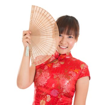 Asian girl with Chinese traditional dress cheongsam or qipao holding Chinese fan. Chinese new year concept, female model isolated on white background.