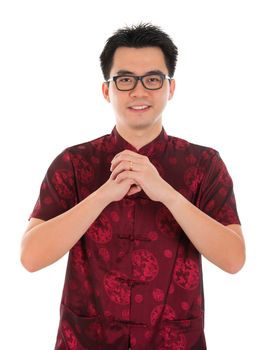Asian man with Chinese traditional dress cheongsam or tang suit greeting. Chinese new year concept, male model isolated on white background.