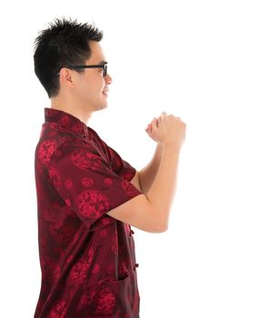 Side view Asian man with Chinese traditional dress cheongsam or tang suit greeting. Chinese new year concept, male model isolated on white background.