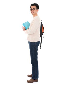 Full body Asian adult student in casual wear with school bag carrying text books standing isolated on white background. Asian male model.