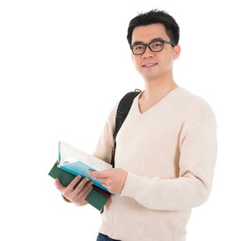 Asian adult male student in casual wear with school bag carrying text books standing isolated on white background. Asian male model.