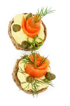 Two Delicious Snacks with Smoked Salmon, Greens, Cheese Cream and Capers isolated on white background. Top View