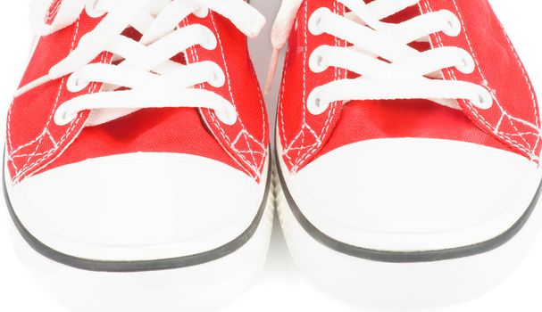 Noses of Trendy Red Gym Shoes closeup on white background