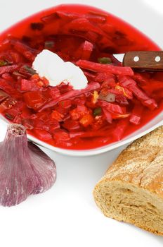 Delicious Traditional Beet Soup Borscht Arranging with Garlic and Brown Bread closeup on white background
