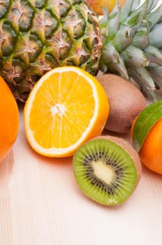 Tropical Fruits - Pineapple, Oranges, Tangerine and Kiwi on Wooden Table With Copyspace