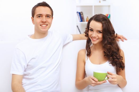 Young happy couple at hone together sitting and talking