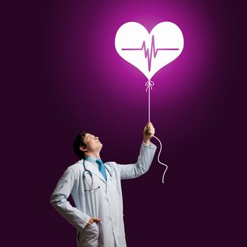 Young male doctor cardiologist with heart symbol